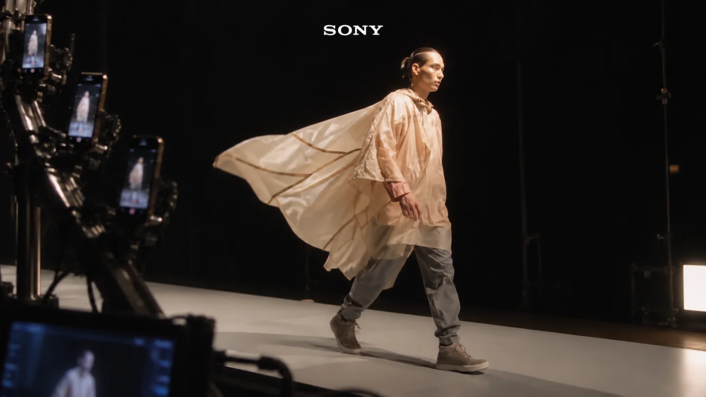 A reconstructed Sony Mobile VS Fashion campaign still with the model crossing the black catwalk beside the smartphone capture rig