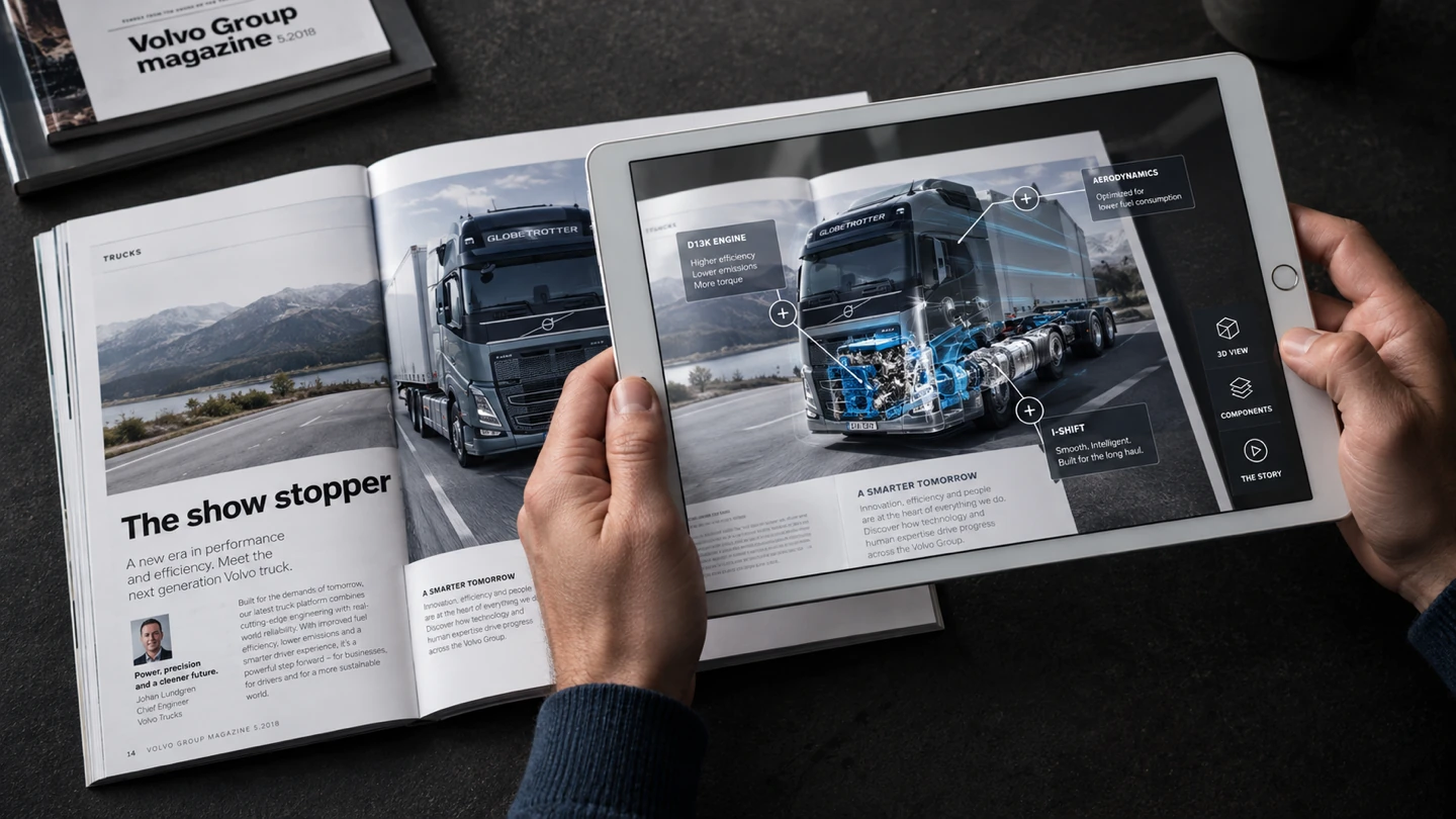 Volvo Group Magazine open on a dark table while a tablet reveals an augmented-reality technical view of a Volvo truck