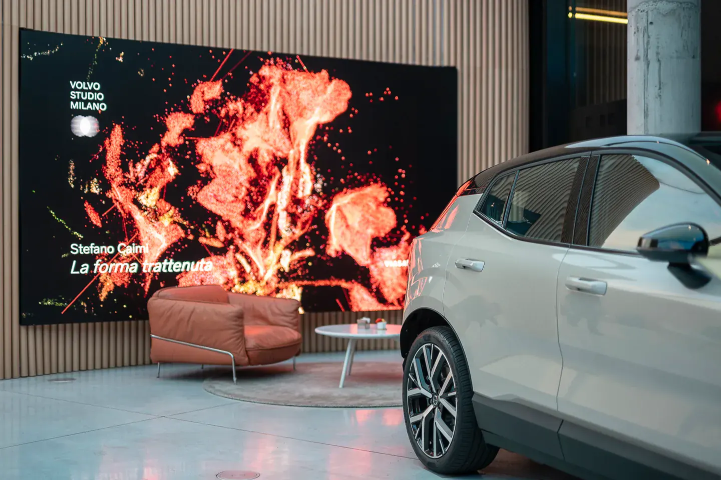 A Volvo car beside a large digital artwork in the Milan Studio Store